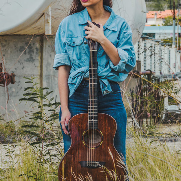 woman holding Washburn acoustic guitar outside