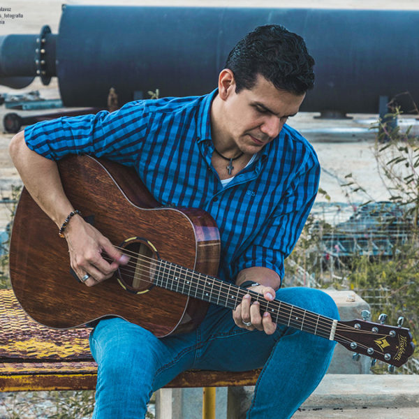 man playing Washburn acoustic guitar outside