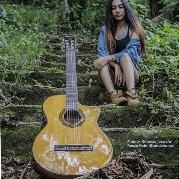 girl sitting behind Washburn acoustic guitar on outdoor steps