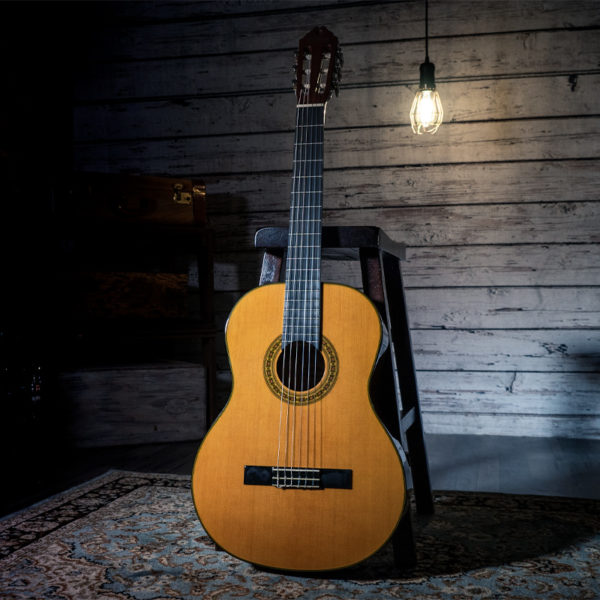 Washburn classical guitar leaning on stool