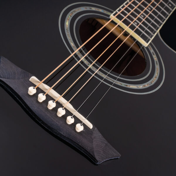 closeup of body of black acoustic guitar