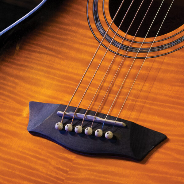 closeup of bridge on yellow acoustic guitar