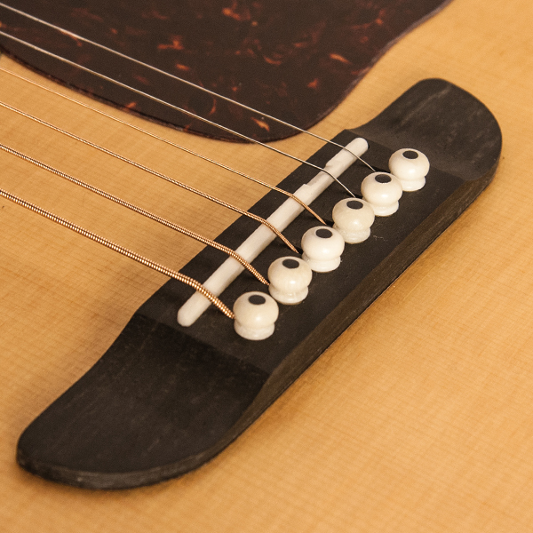 closeup of bridge and saddle on Washburn acoustic guitar