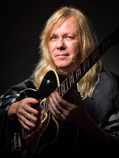 World-renowned guitarist Victor Biglione holding an acoustic guitar.