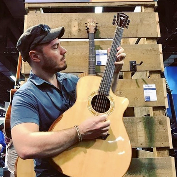 man playing Washburn acoustic guitar in store