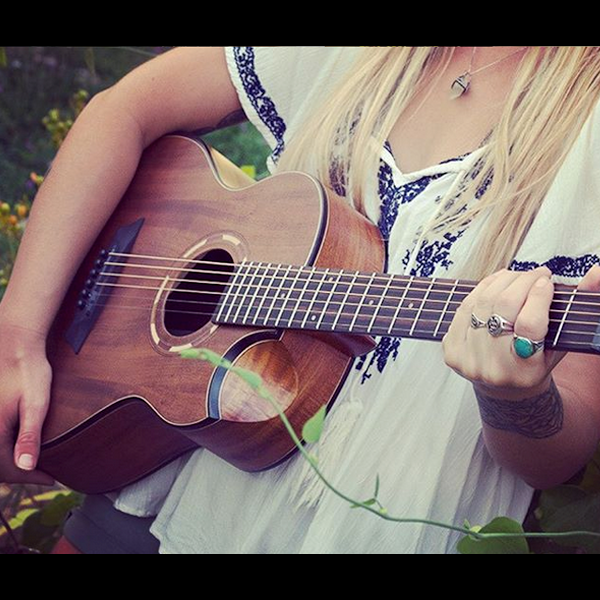 partial view of woman playing Washburn acoustic guitar