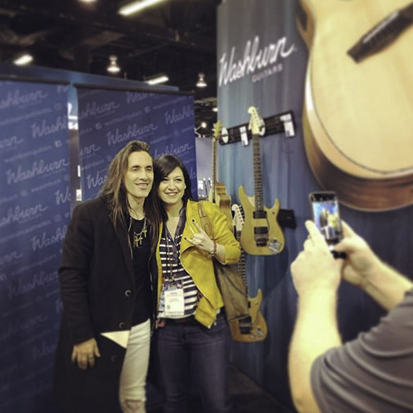 woman posing for picture with musician at Washburn event