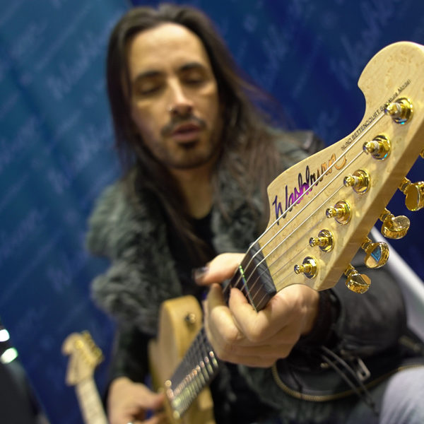 headstock of Washburn electric guitar being played by male musician