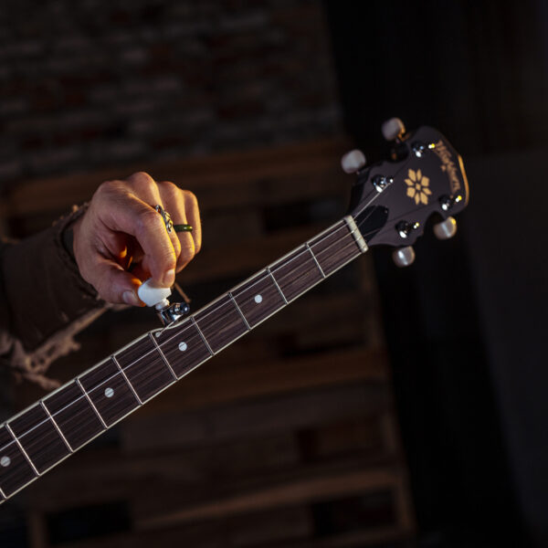 image of a man tuning a Washburn B7 Banjo